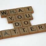 Wooden letter tiles spelling 'What You Do Matters' on a neutral background.